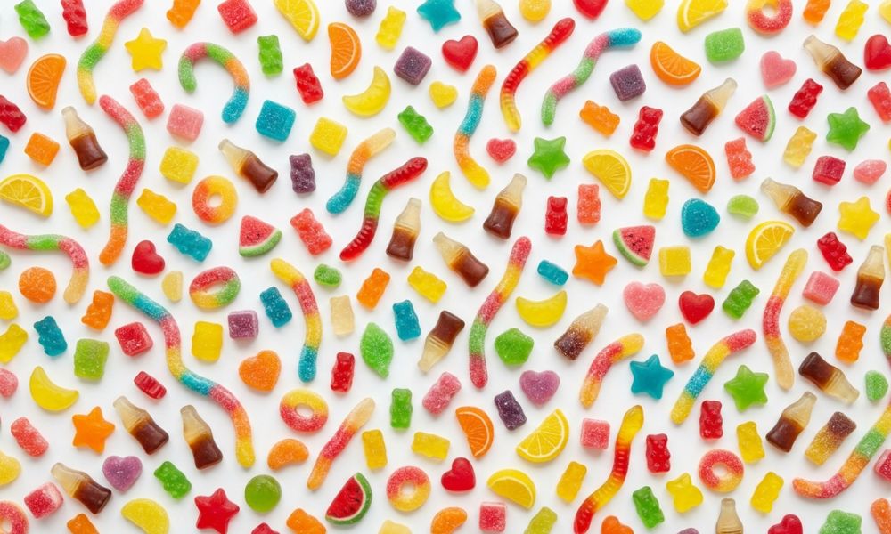 A colourful spread of halal-certified gummy sweets and jelly shapes on a white background